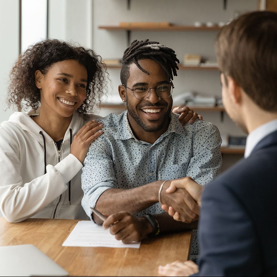 Couple shaking hands with a man in a suit